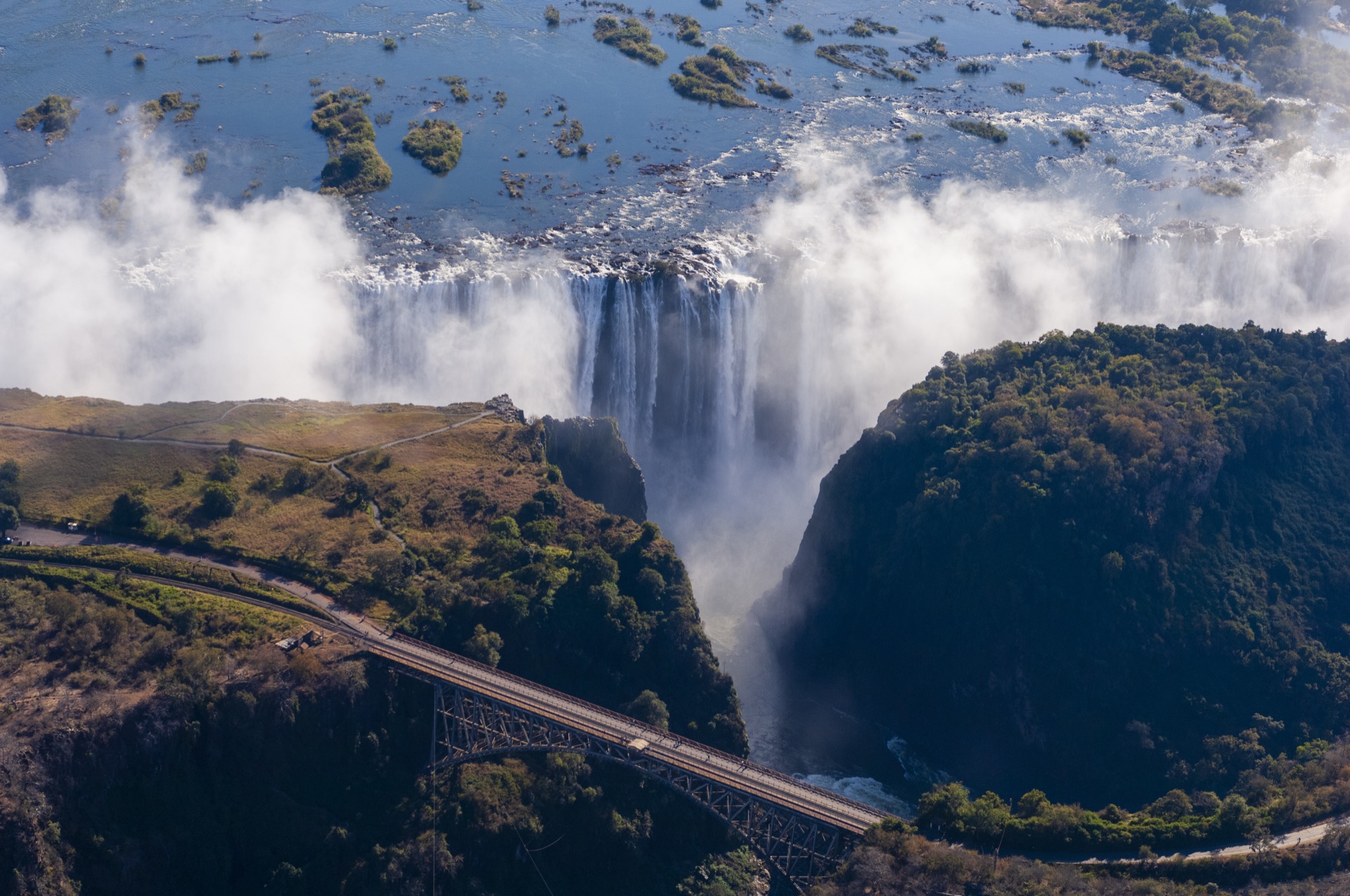 Majestic waterfall cascading into mist-covered gorge